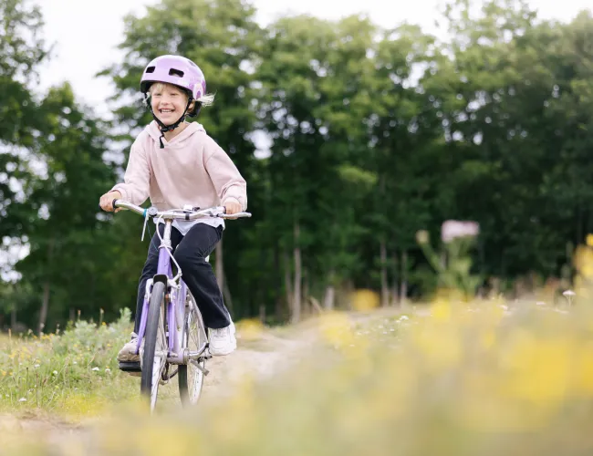 Barn cyklar på camping