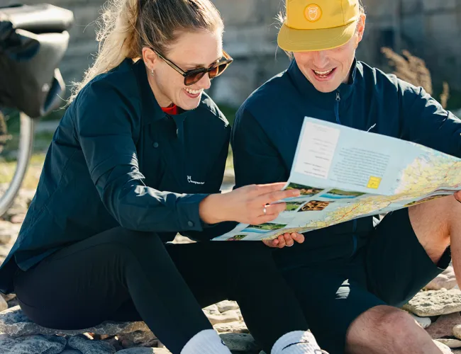 Två personer kollar på en cykelkarta 